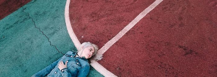 High angle view of young woman lying on back outdoors