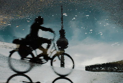 High angle view of person riding bicycle on puddle