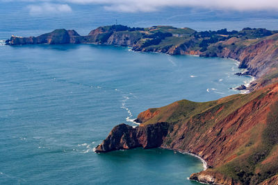 Scenic view of sea and mountains against sky