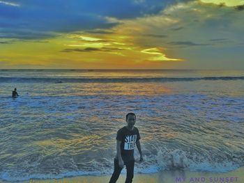 Man standing on beach against sky during sunset