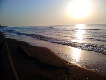 Scenic view of beach against clear sky during sunset