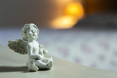 Close-up of angel statue on table