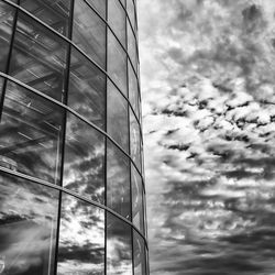 Low angle view of modern building against cloudy sky