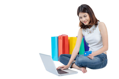 Young woman using mobile phone against white background