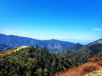 Scenic view of mountains against blue sky