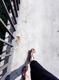 Low section of woman standing on staircase