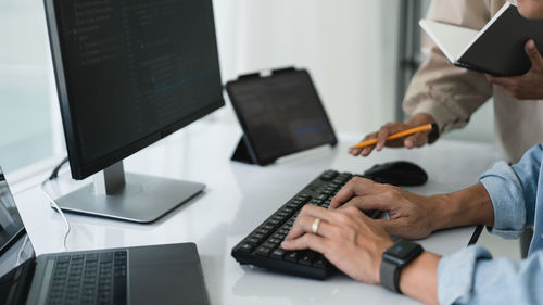 Midsection of man using laptop on table