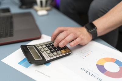 Businessman using calculator while working at home