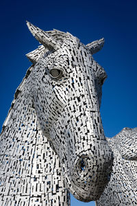 Low angle view of statue against clear blue sky