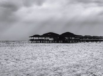 Built structure by sea against sky