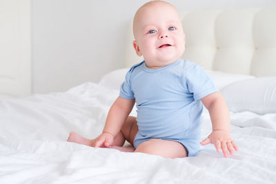 Portrait of cute baby boy sleeping on bed at home