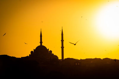 Silhouette of mosque against sky during sunset