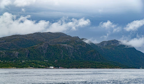 Scenic view of sea and mountains against sky