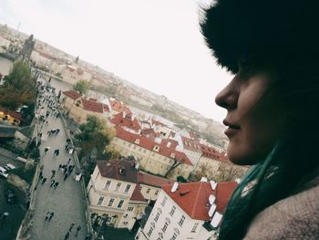 Close-up of woman by cityscape against clear sky