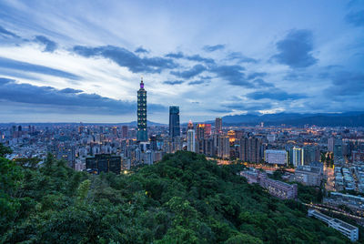 High angle view of city buildings against cloudy sky