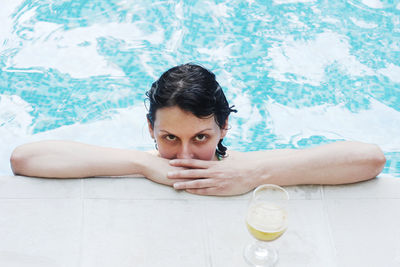 Portrait of woman in swimming pool by drink