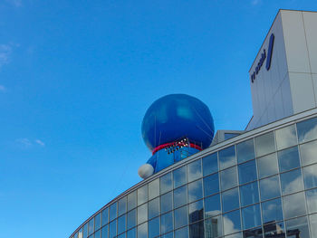 Low angle view of modern building against blue sky