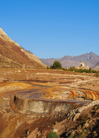 Scenic view of landscape and mountains against clear blue sky