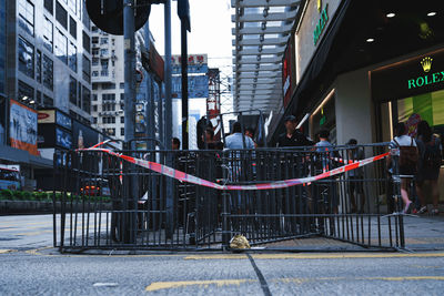 People walking on sidewalk by buildings in city