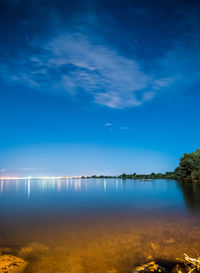 Scenic view of lake against sky at night