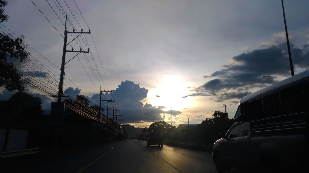 CARS ON ROAD AGAINST SKY AT SUNSET