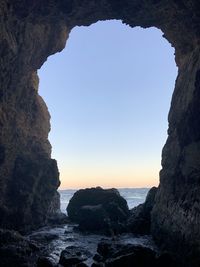 Rock formations on beach against clear sky