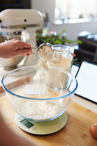 Midsection of person having food in kitchen at home