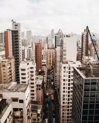 Buildings in city against cloudy sky