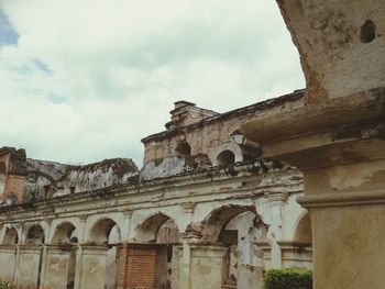 Low angle view of old building against cloudy sky