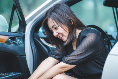 Young woman sitting in car