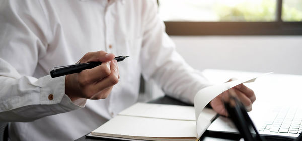 Midsection of businessman working at office