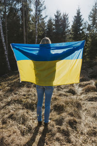 Rear view of woman holding ukrainian flag