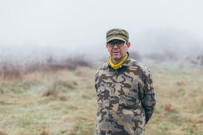 Portrait of smiling man standing on field