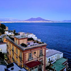 High angle view of buildings by sea against sky