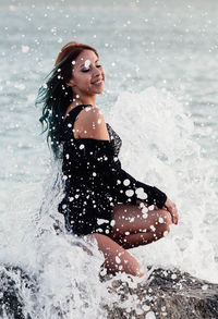 Young woman splashing water in sea