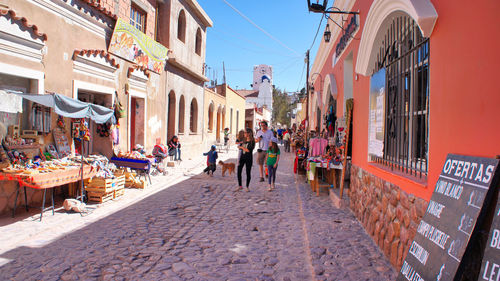 People walking on street amidst buildings in city