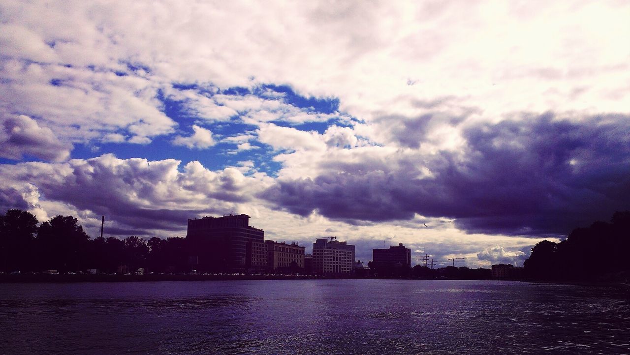 building exterior, architecture, waterfront, built structure, water, sky, city, cloud - sky, cityscape, river, cloudy, cloud, skyscraper, sea, urban skyline, silhouette, dusk, building, residential building, skyline