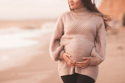 Midsection of woman standing on beach