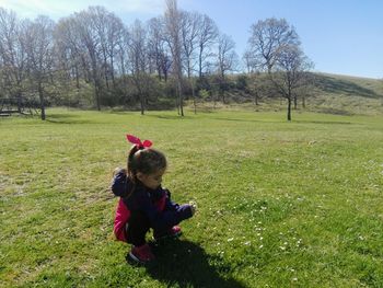 Full length of cute girl crouching on grass