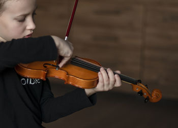 Close-up of boy playing violin