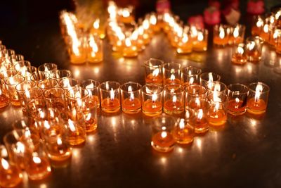 Illuminated candles on glass table
