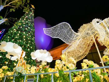 Low angle view of illuminated christmas decorations at night