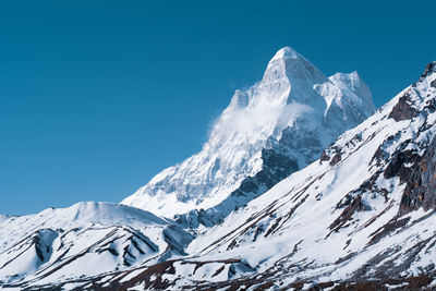 Scenic view of snowcapped mountains against clear blue sky at the place of gomukh region in india.