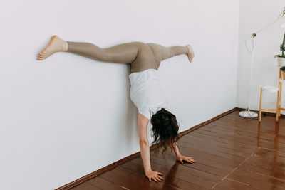 A girl in sportswear goes in for sports with yoga, exercises and fitness in the studio