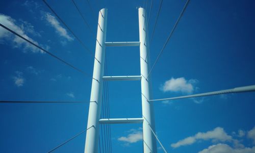 Low angle view of telephone pole against blue sky