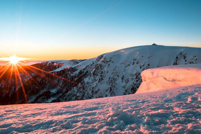 Scenic view of snow covered mountains against sky during sunset