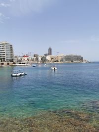 Scenic view of sea and buildings against sky