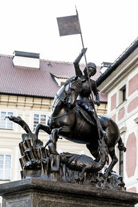 Low angle view of statue against building in city