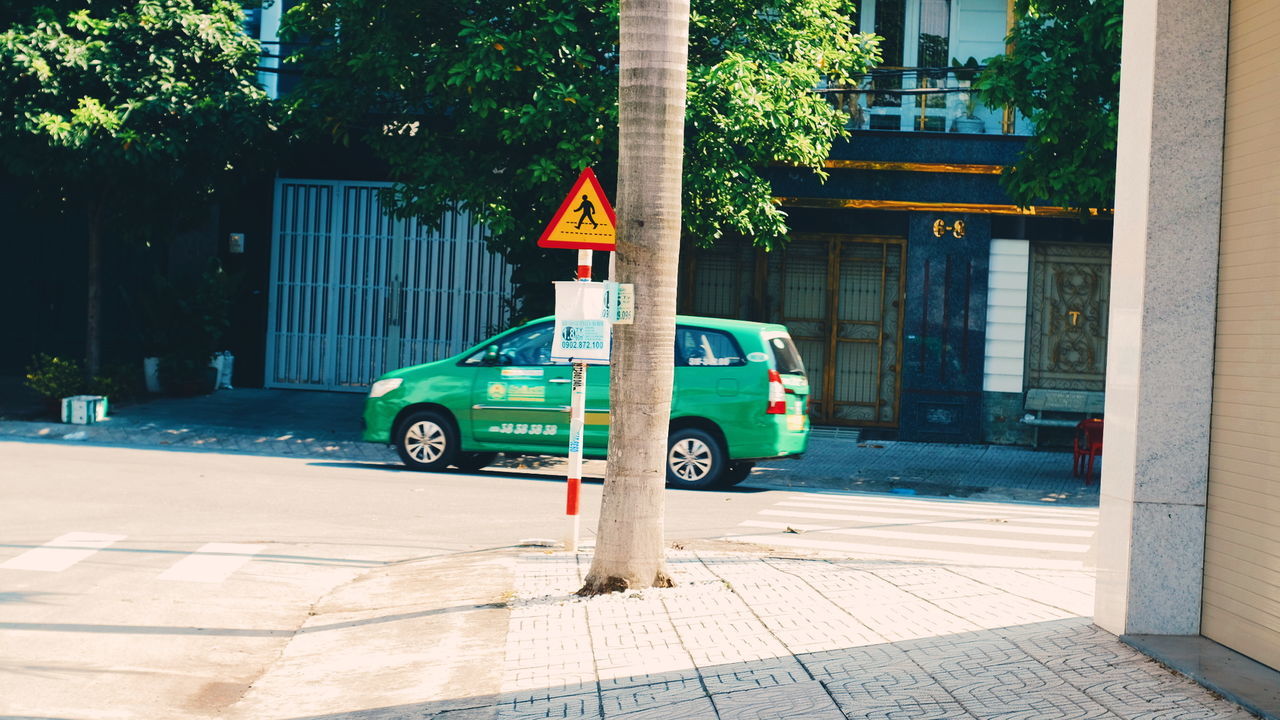 city, architecture, street, mode of transportation, transportation, building exterior, land vehicle, built structure, tree, car, motor vehicle, day, road, plant, no people, building, sunlight, nature, outdoors