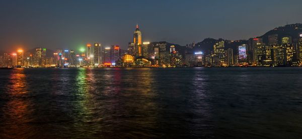 Illuminated buildings in city against sky at night